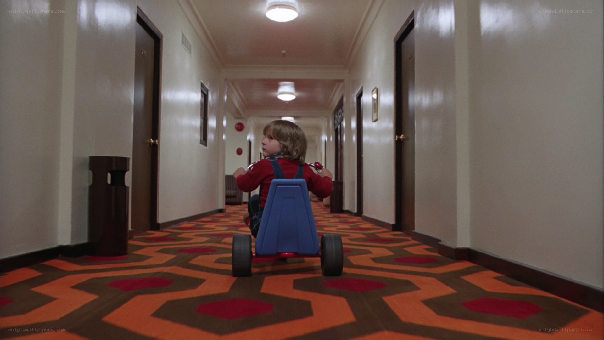 child in tricycle hallway