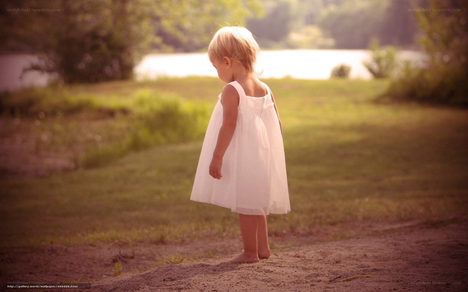 child in white dress by lake