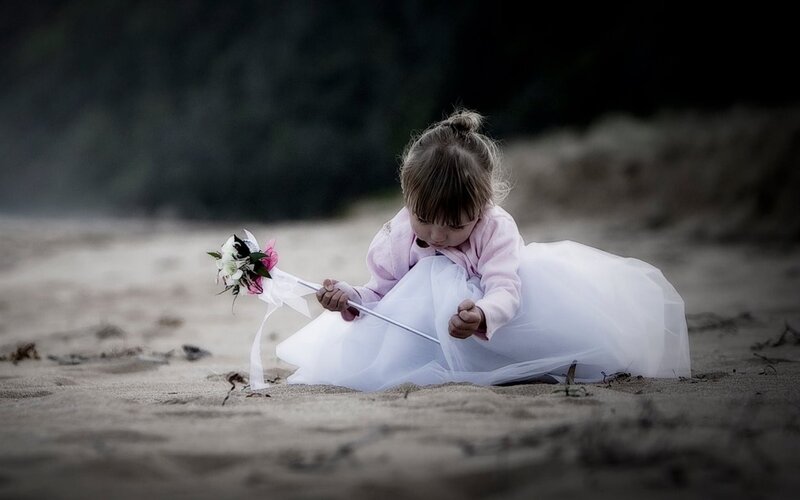 child in white dress on beach