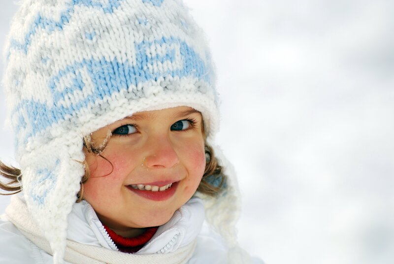 child in winter hat smiling