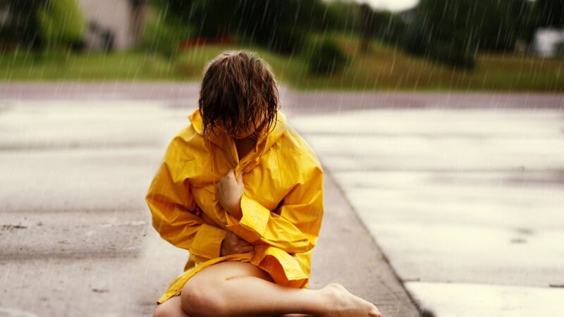 child in yellow raincoat in rain