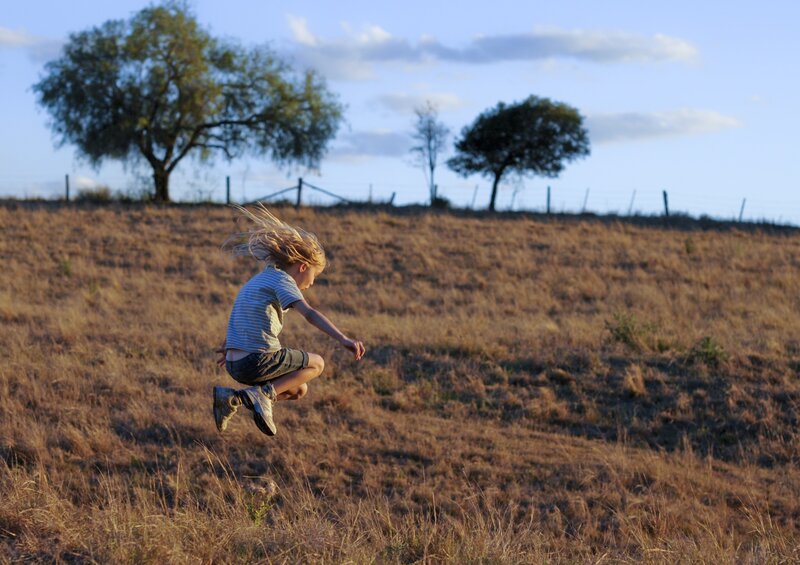 Child jumping in a field