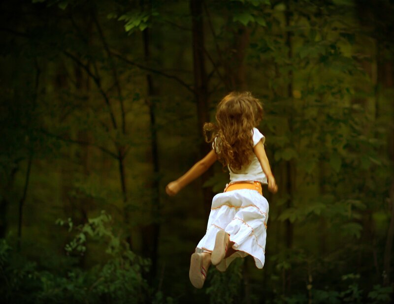 child jumping in forest