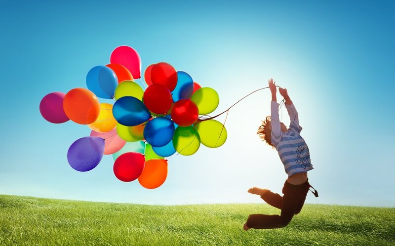 Child jumping with balloons