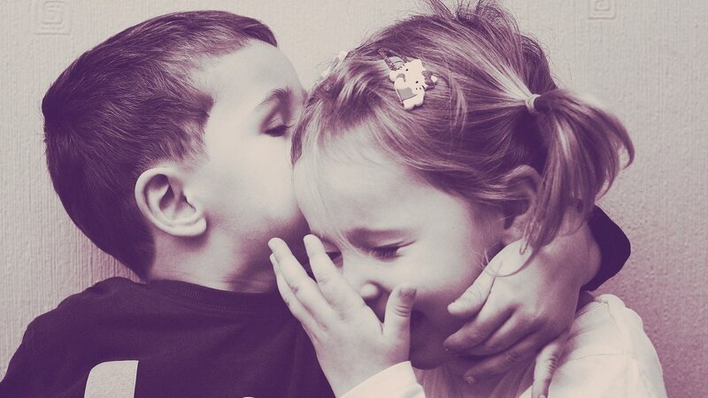child kissing sibling