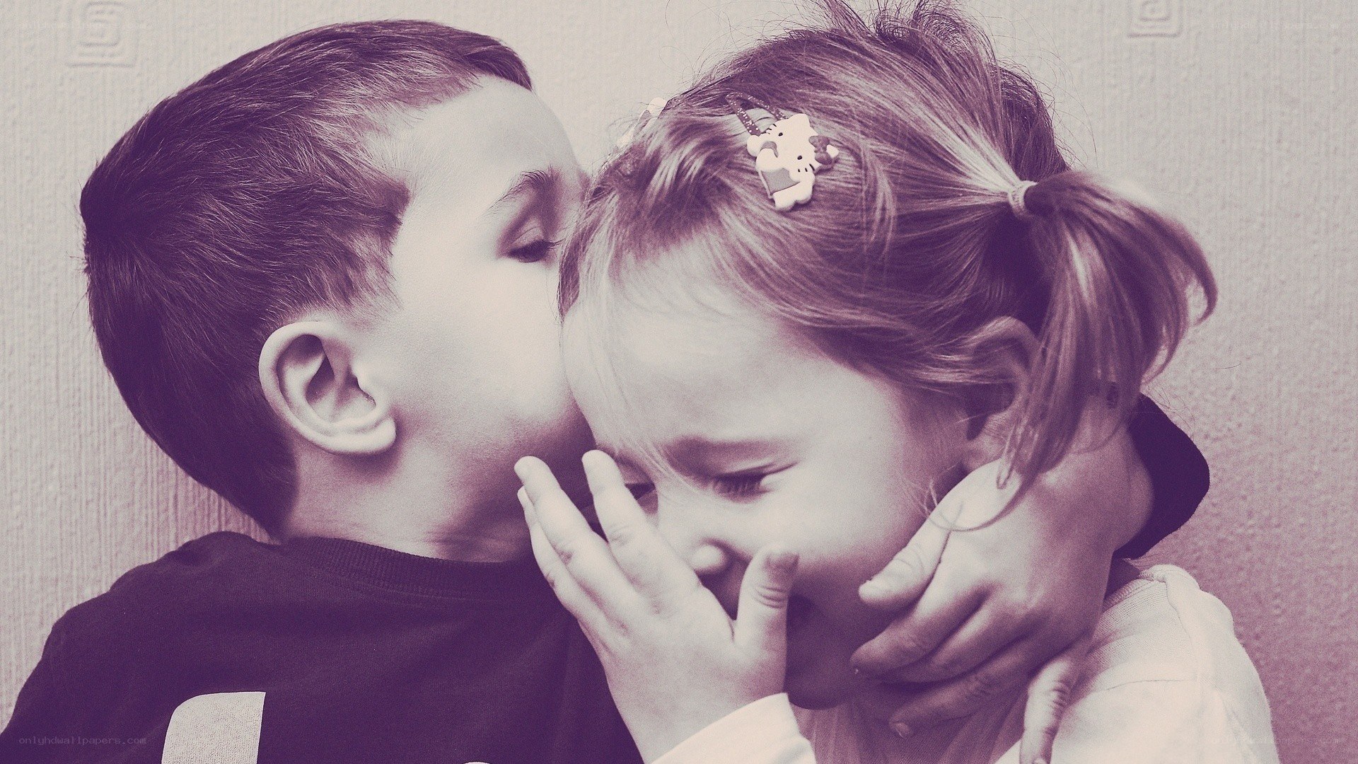 child kissing sibling