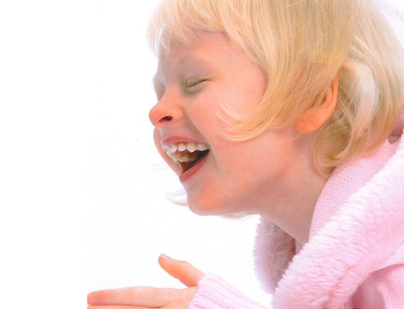 child laughing in pink sweater