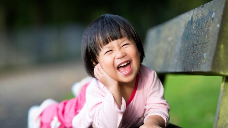 child laughing on bench