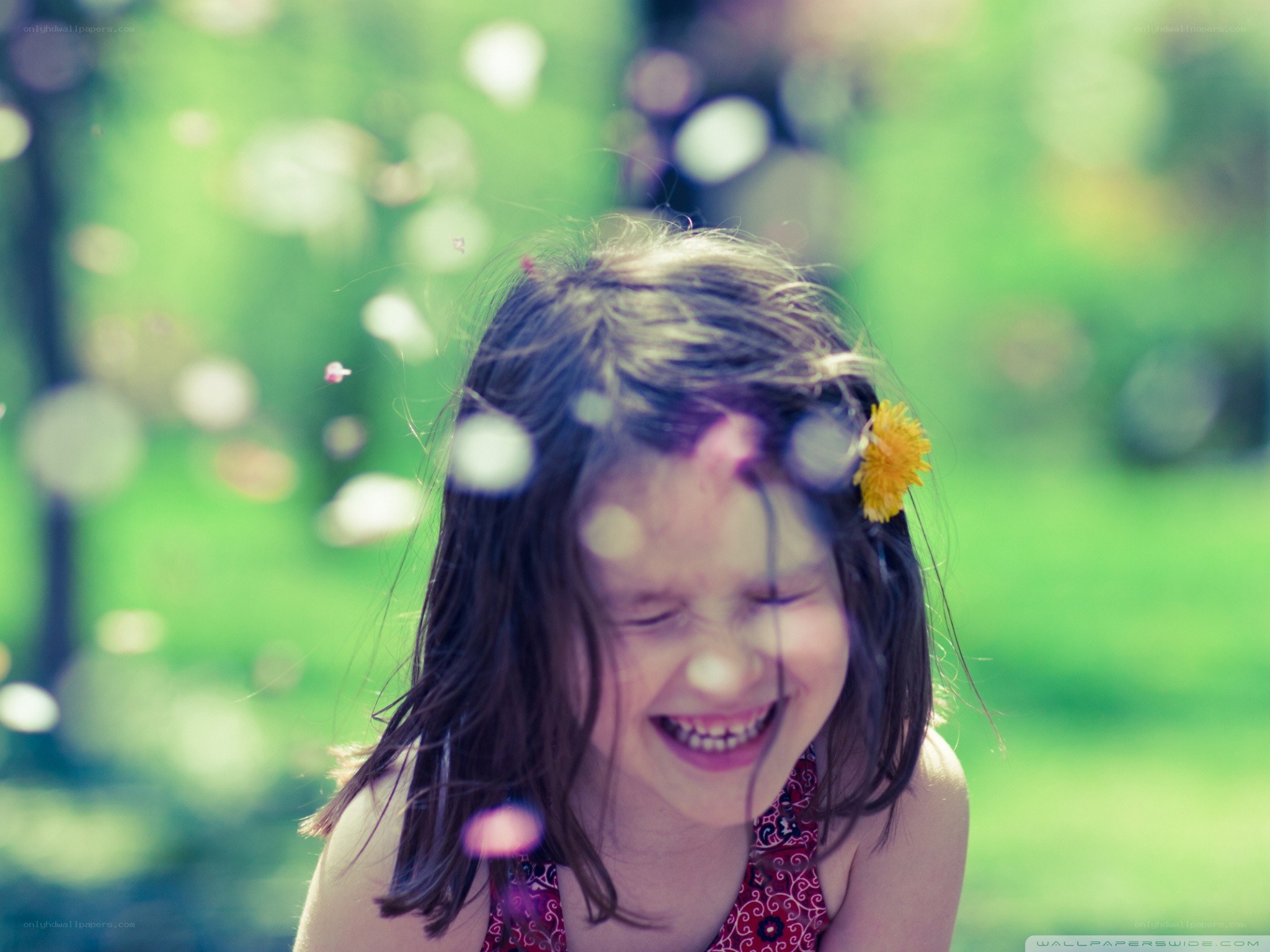 child laughing with dandelion