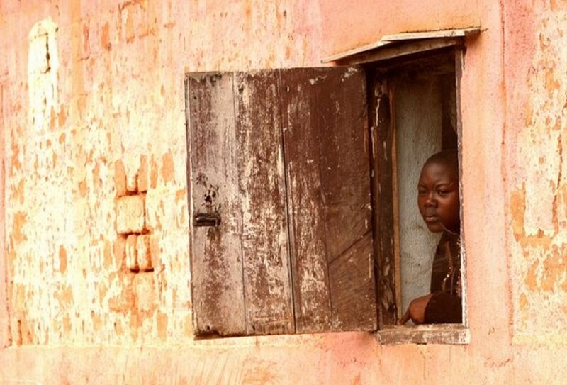 Child Looking Out Window — Orange