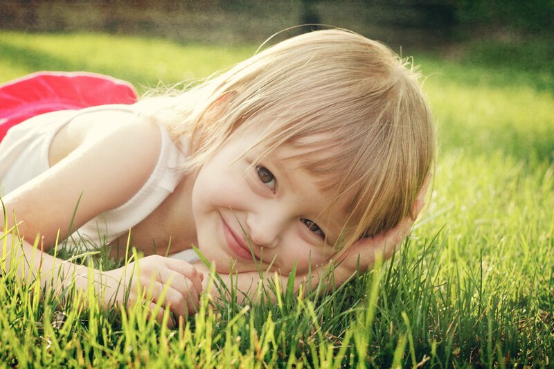 child lying in grass