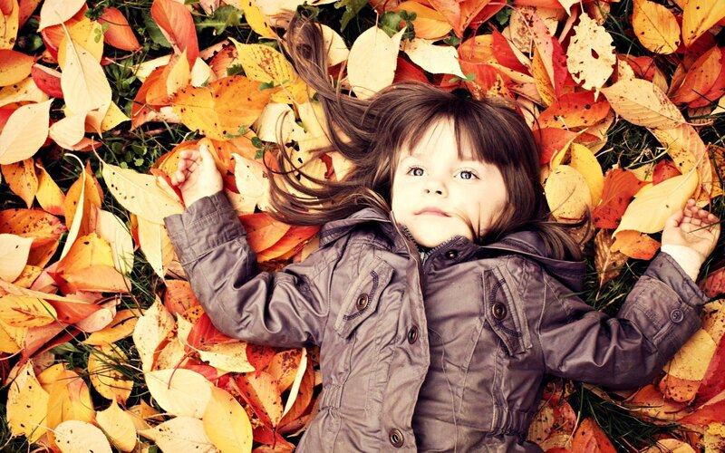 Child Lying in Leaves — Yellow