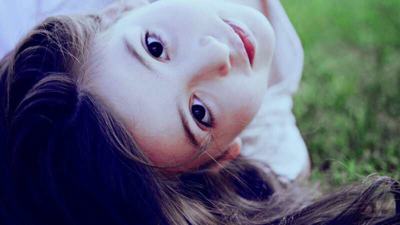 child lying on grass looking up
