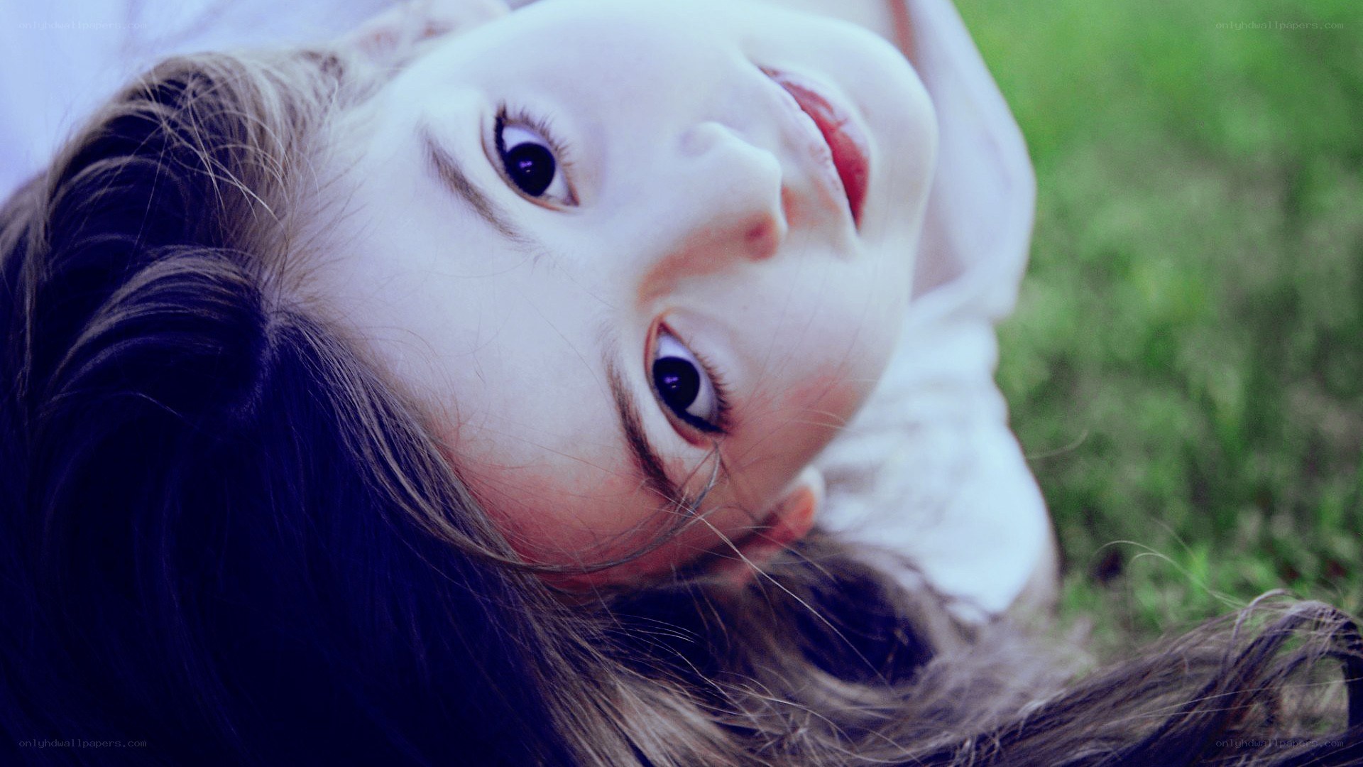 child lying on grass looking up