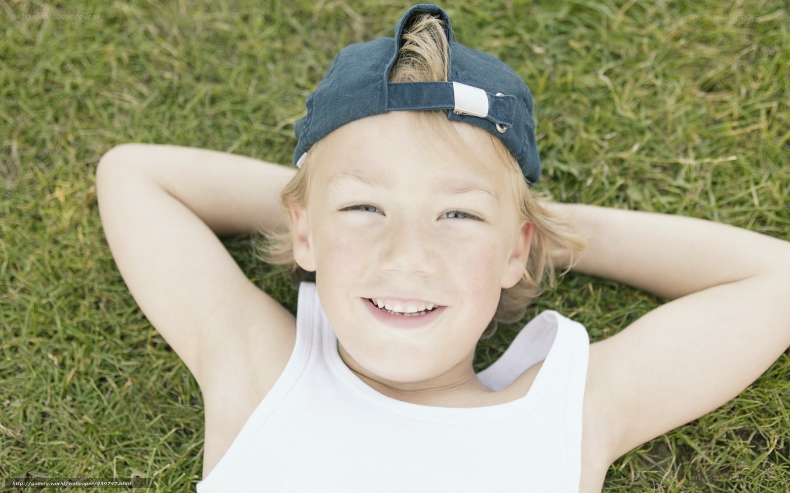 child lying on grass smiling