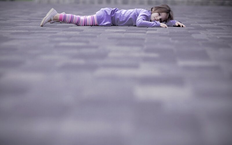 child lying on pavement