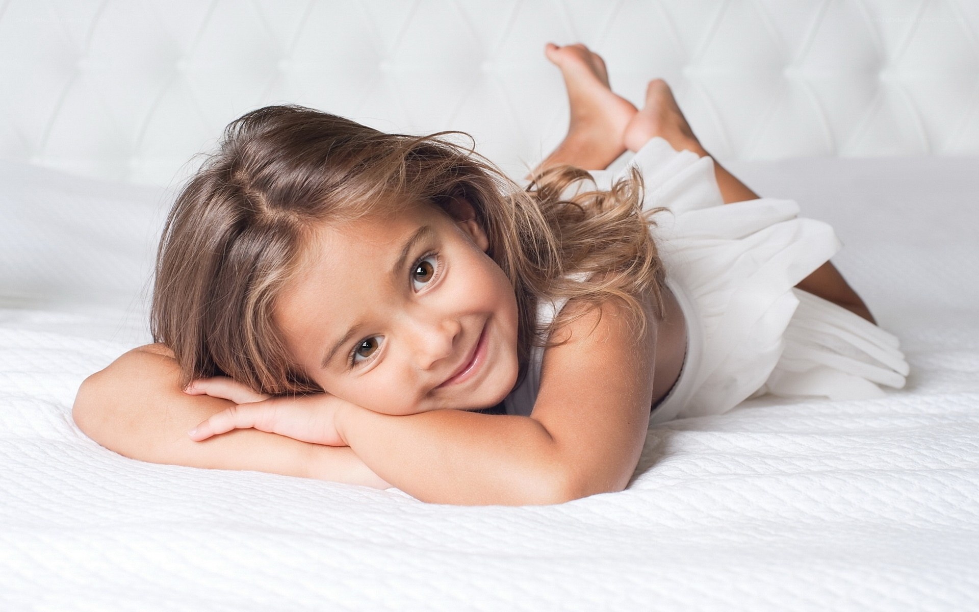 child lying on white bed