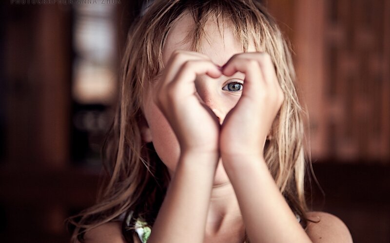 child making heart shape with hands