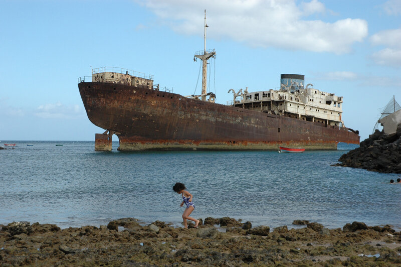 Child near shipwreck on shore