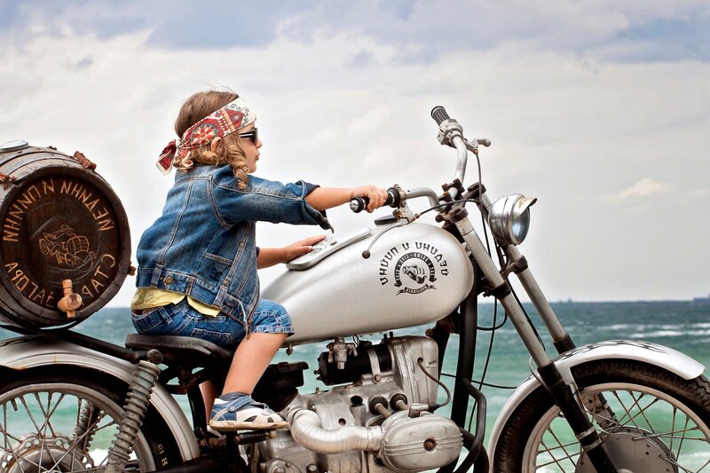 Child on a motorcycle by the sea