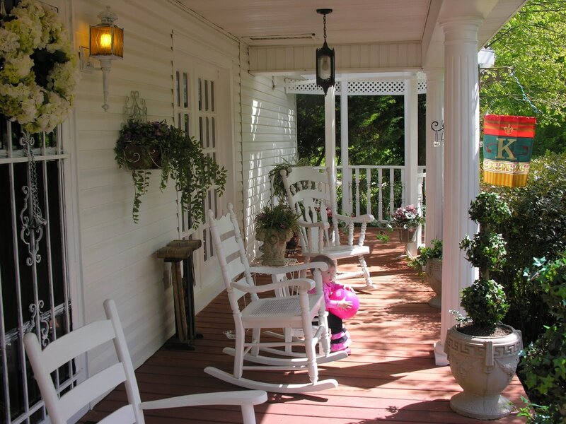 child on a porch with rocking chairs