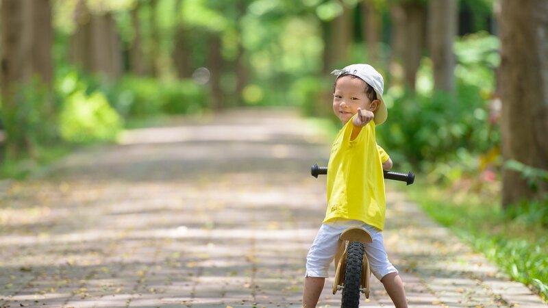 child on balance bike in park