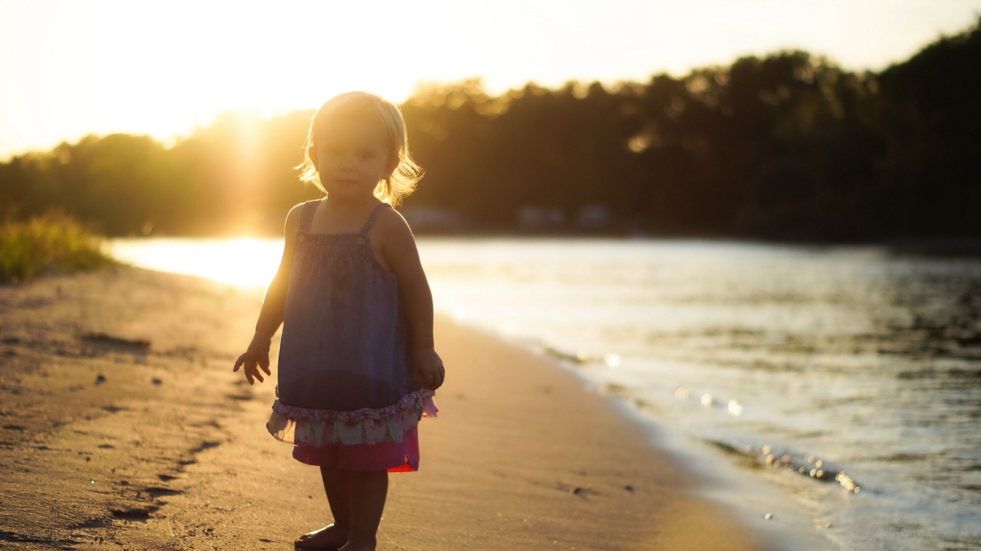 child on beach at sunset