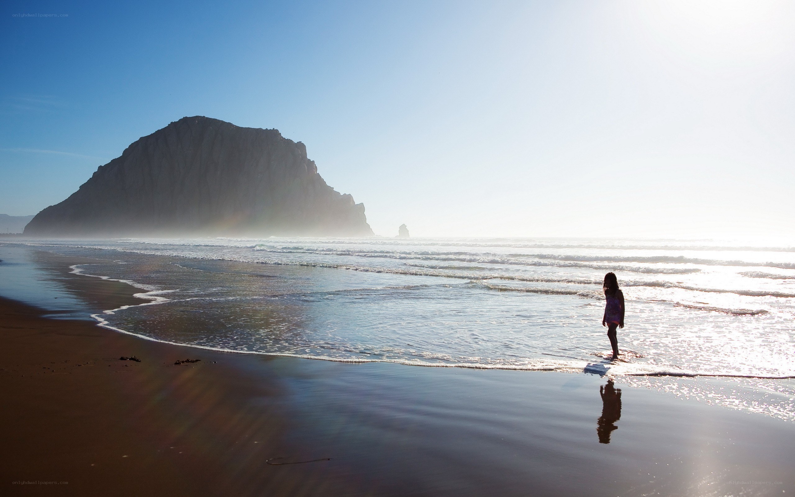 Child on beach near sea stack