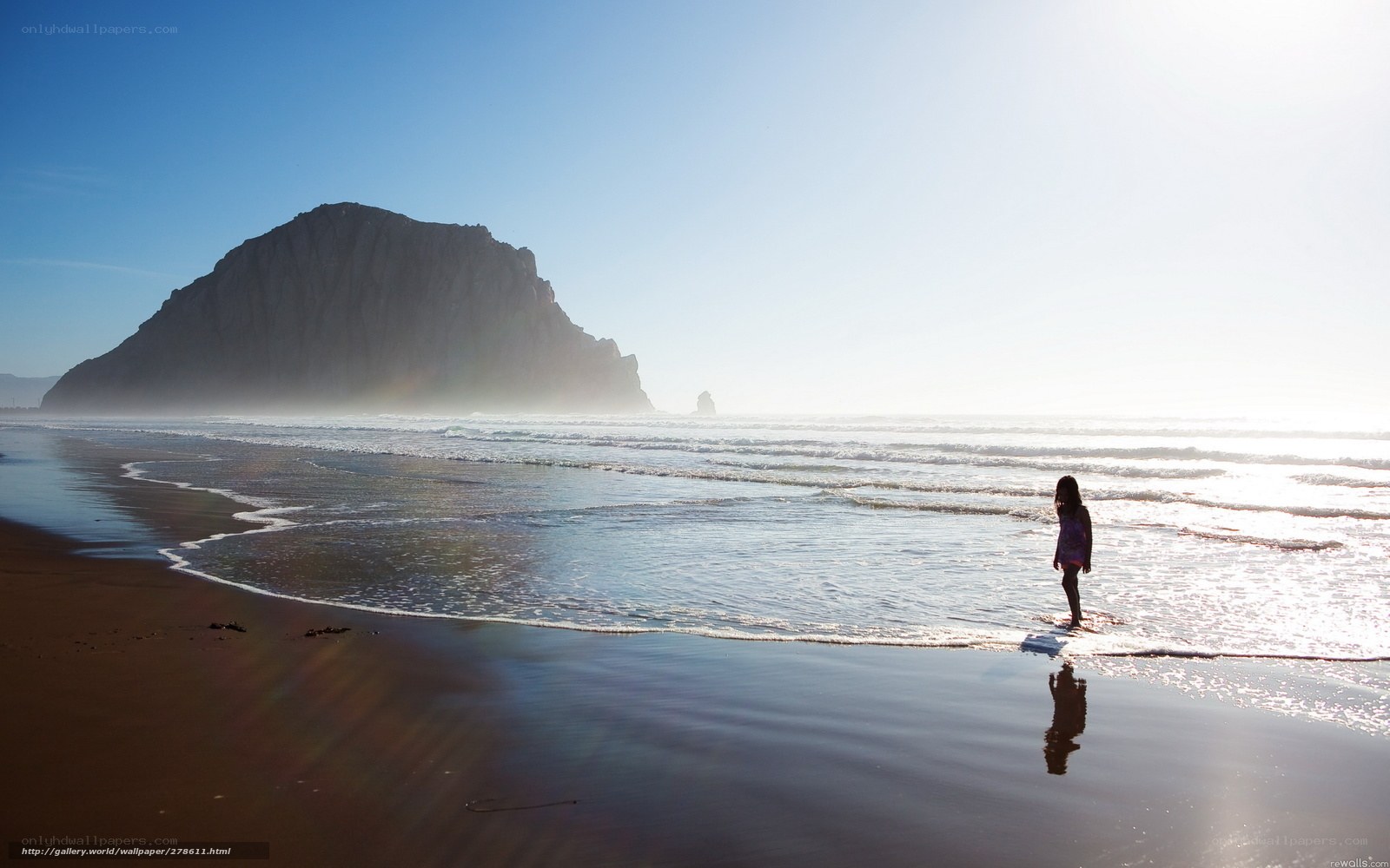 Child on beach near sea stack