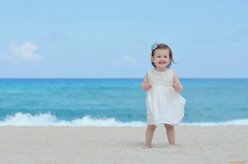 child on beach smiling