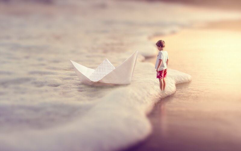 Child on Beach with Paper Boat