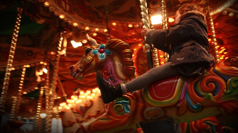 child on carousel at night