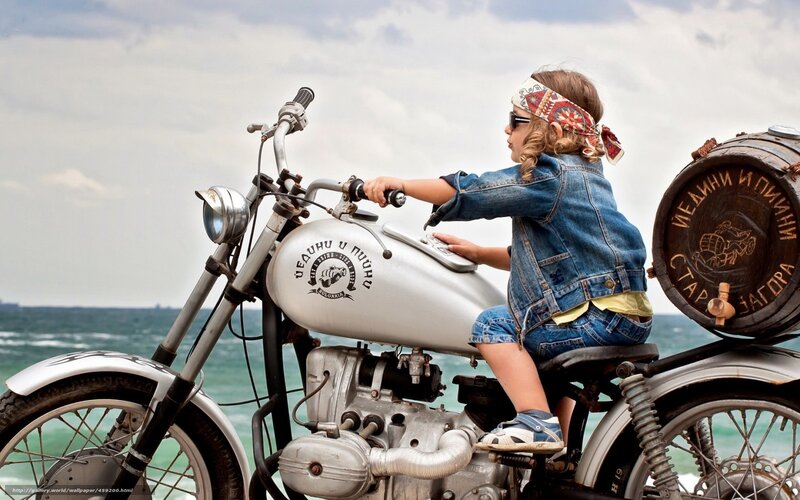 child on motorcycle by sea