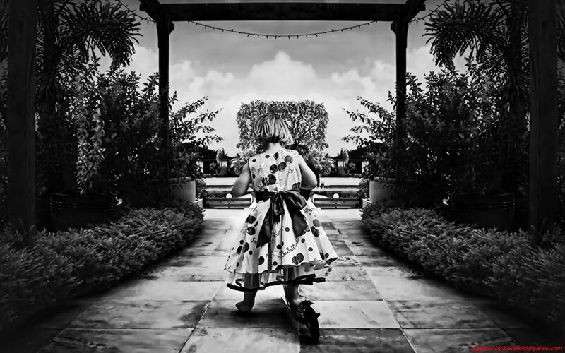 child on scooter in garden