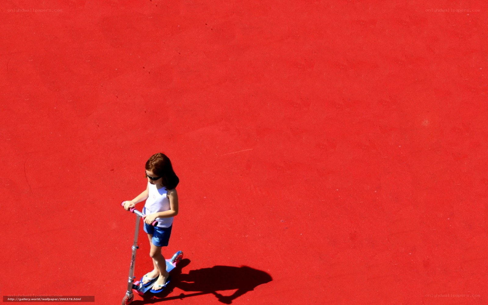child on scooter on red surface