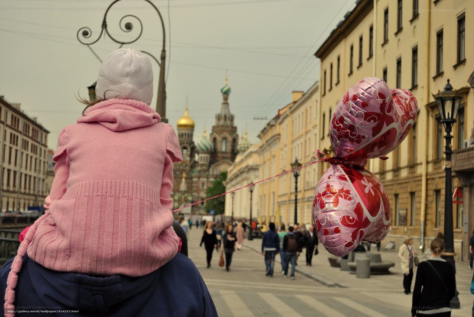 Child on shoulders with balloons