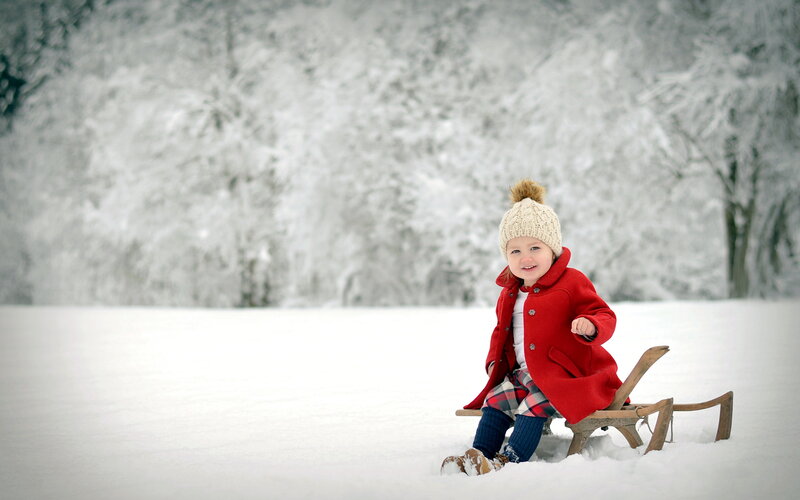Child on Sled in Snow — Red