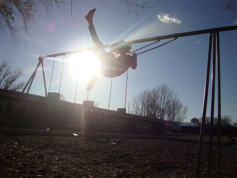 Child on swing at sunset