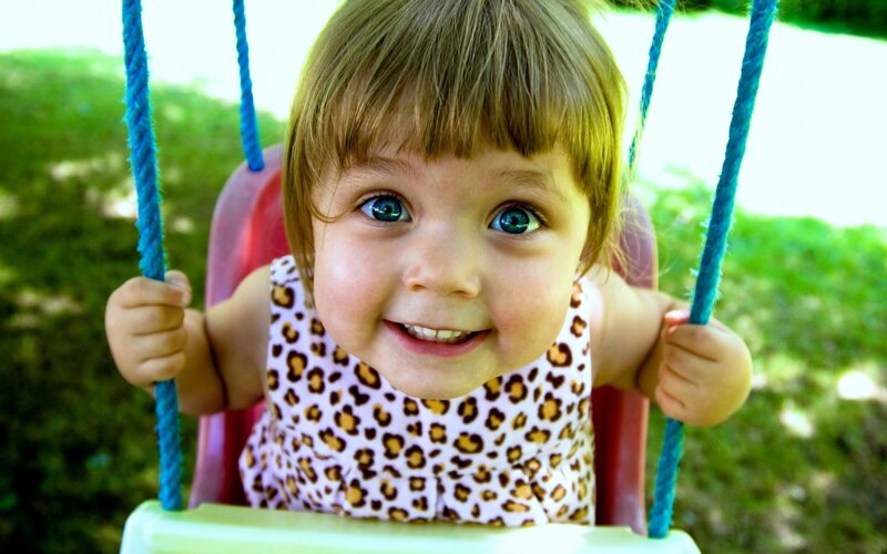 child on swing smiling