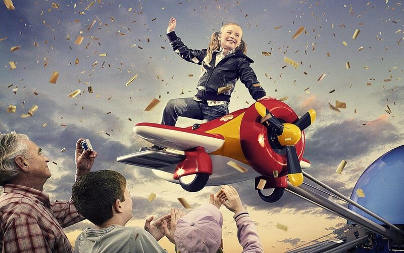 Child on toy airplane in sky