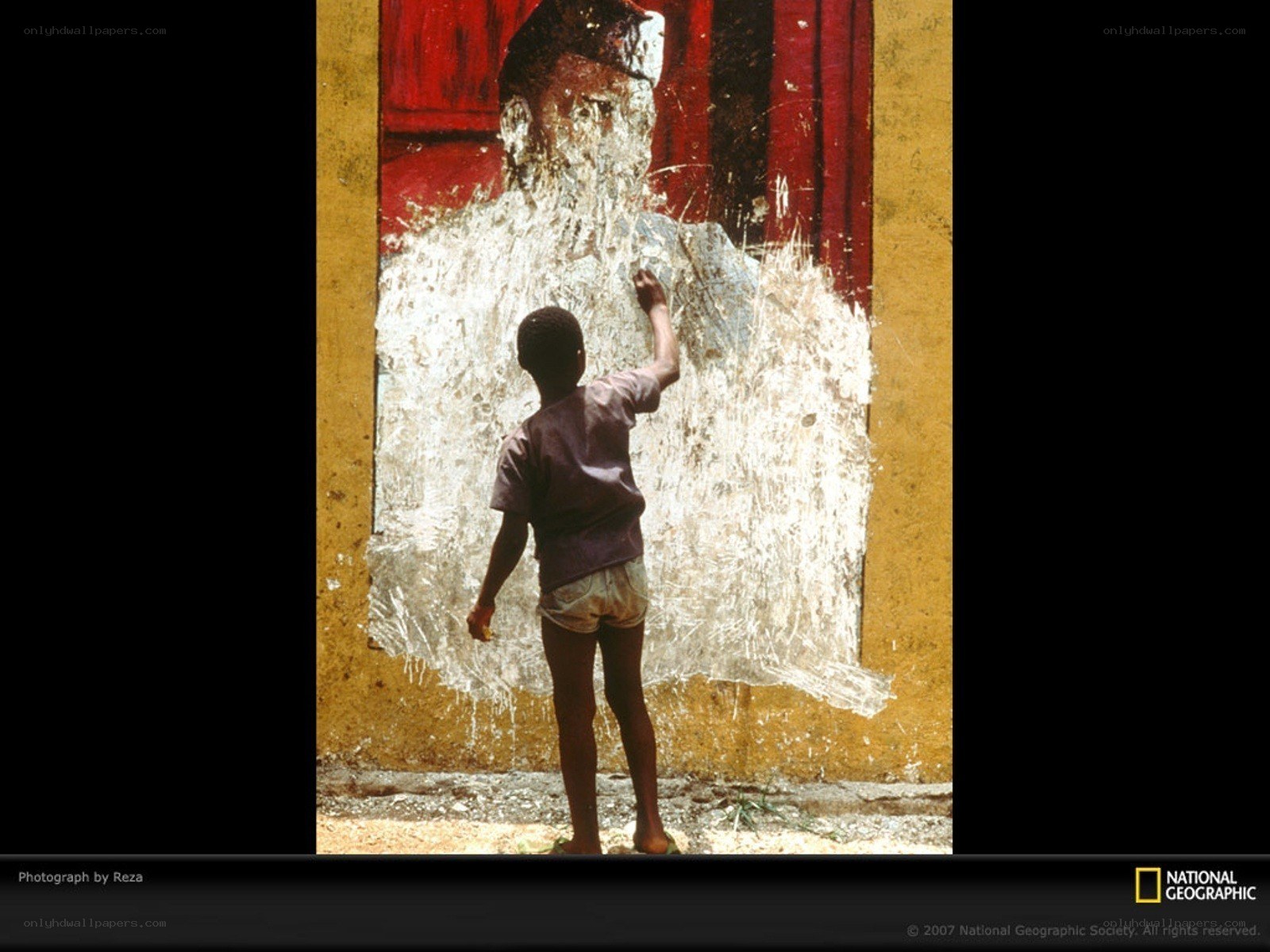 Child painting over mural