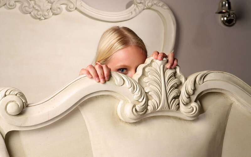 child peeking from bed