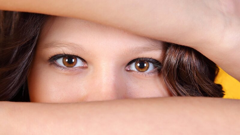 child peeking through hands