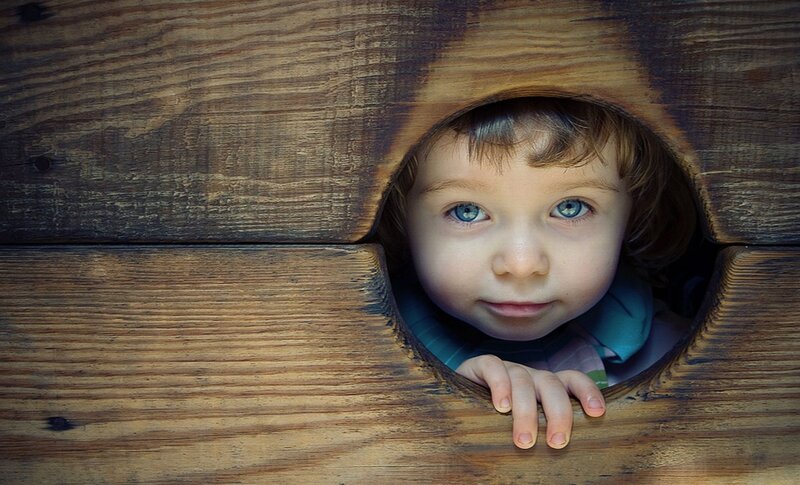 Child Peeking Through Hole
