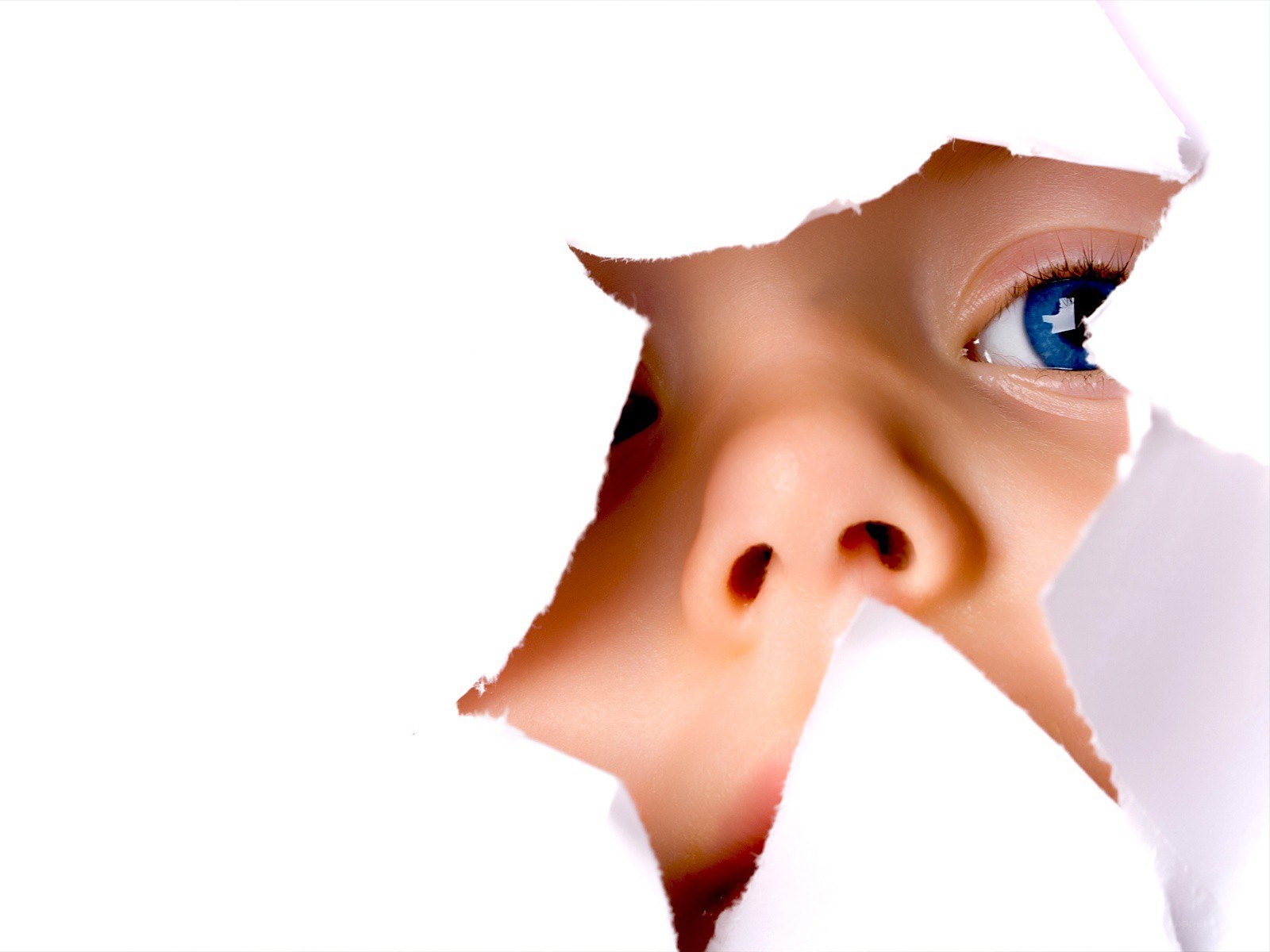 child peeking through torn paper