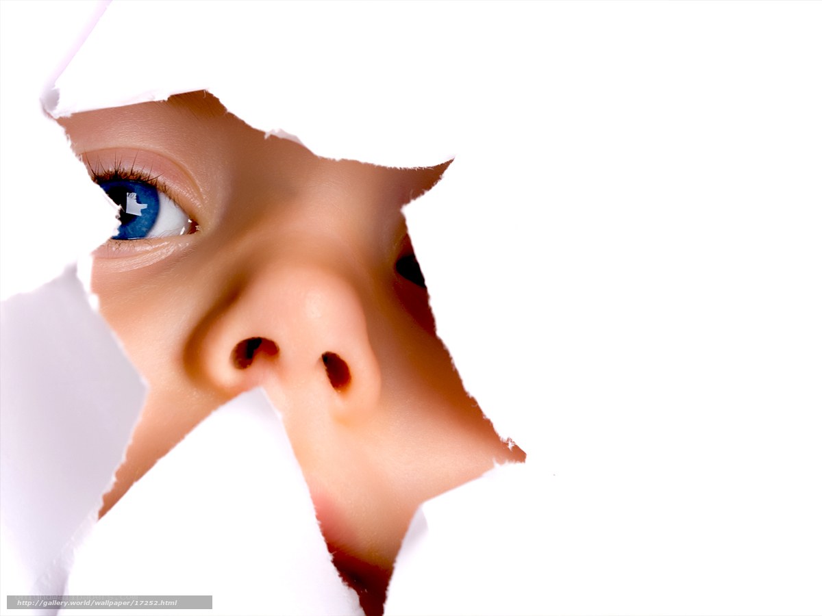 child peeking through torn paper