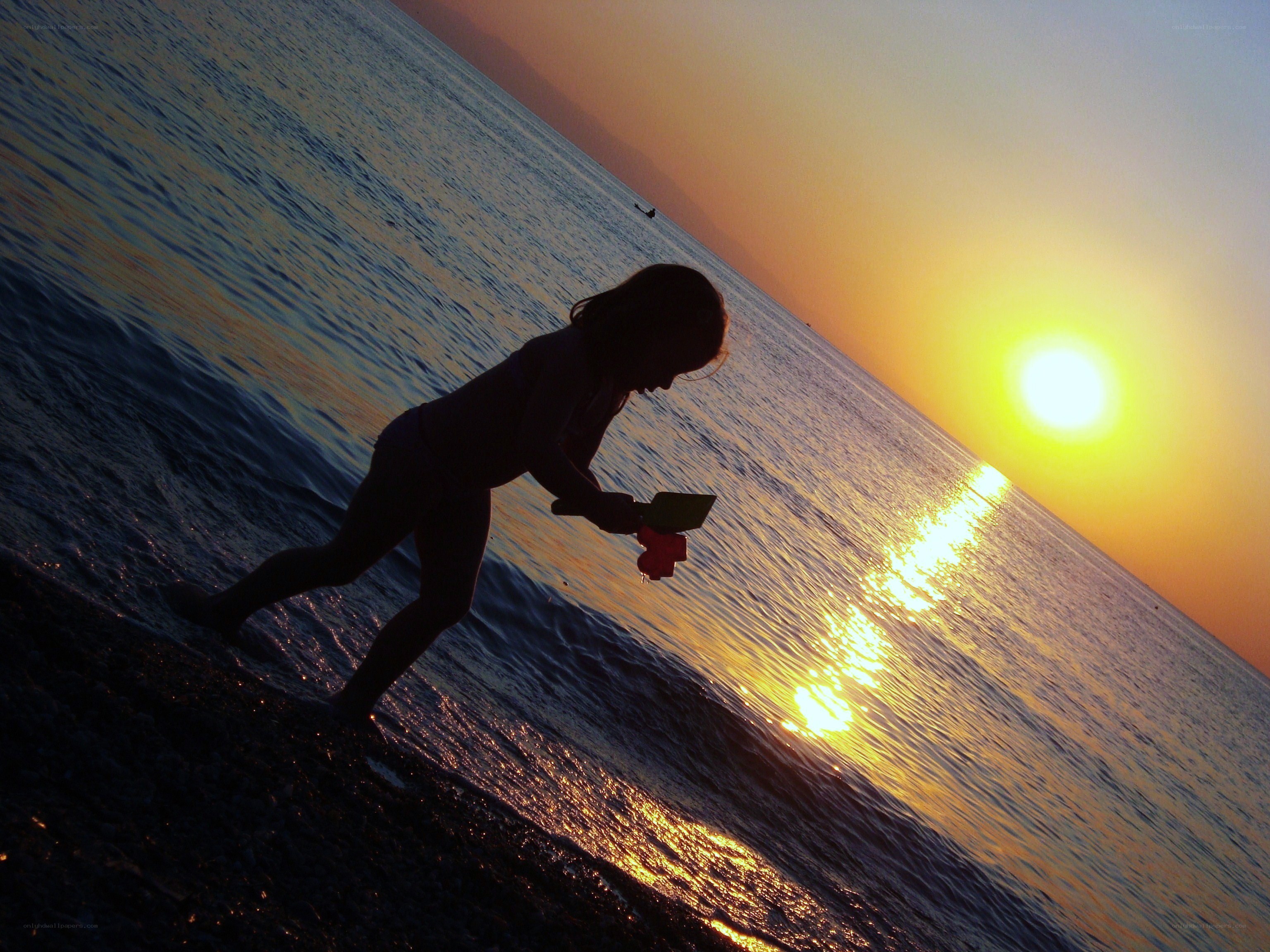 Child playing at sunset on beach