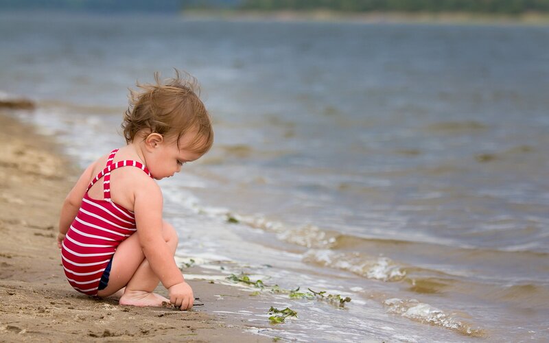 child playing at the beach