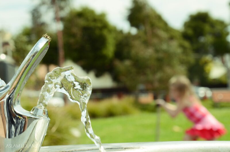 Child playing at water fountain