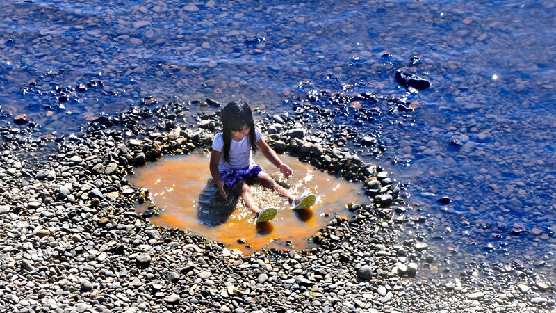 child playing in river water